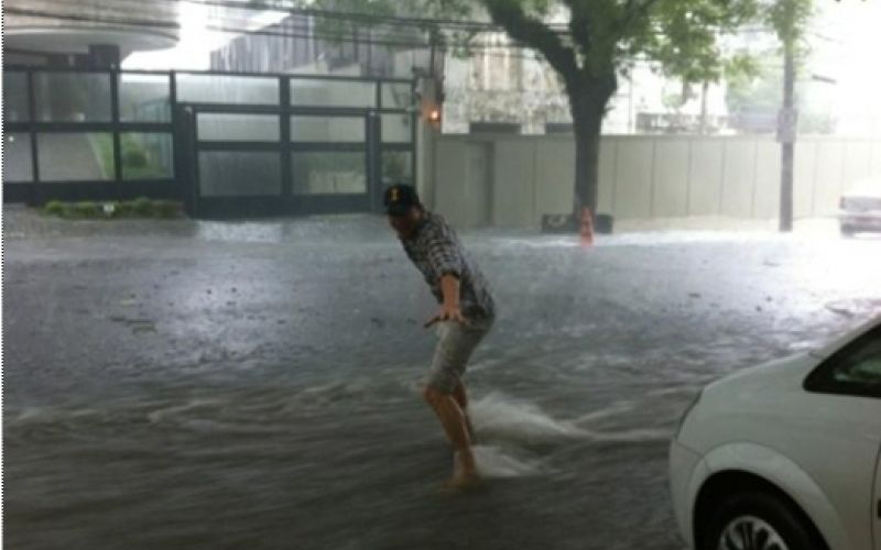 Ashton Kutcher surfa pelas ruas de São Paulo após chuva
